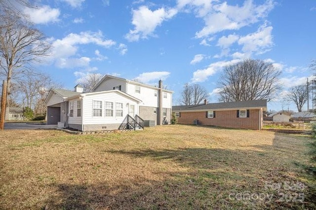 back of house featuring a garage, crawl space, and a yard