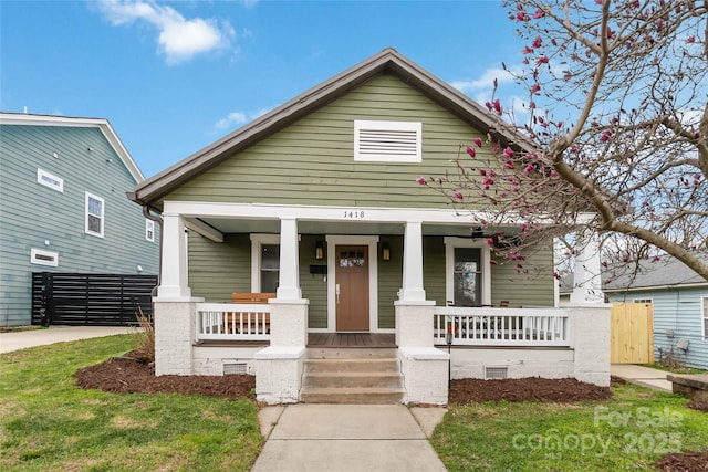 view of front of home featuring a porch, crawl space, and fence