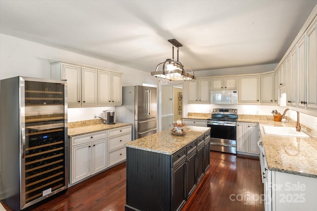 kitchen with light stone countertops, beverage cooler, dark wood finished floors, appliances with stainless steel finishes, and a sink