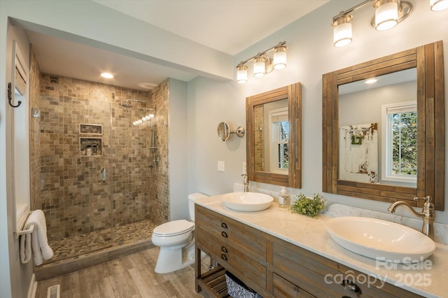 bathroom featuring visible vents, a stall shower, toilet, and a sink