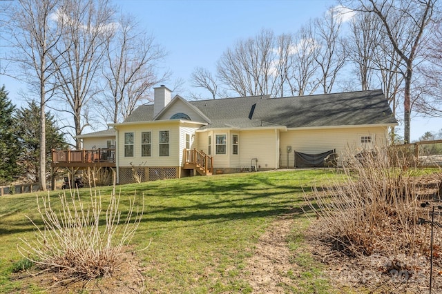 rear view of house featuring a chimney, a lawn, and a wooden deck