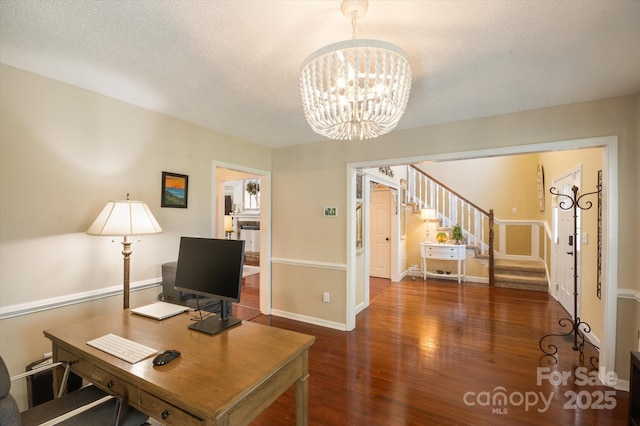 office space with a chandelier, baseboards, a textured ceiling, and wood finished floors