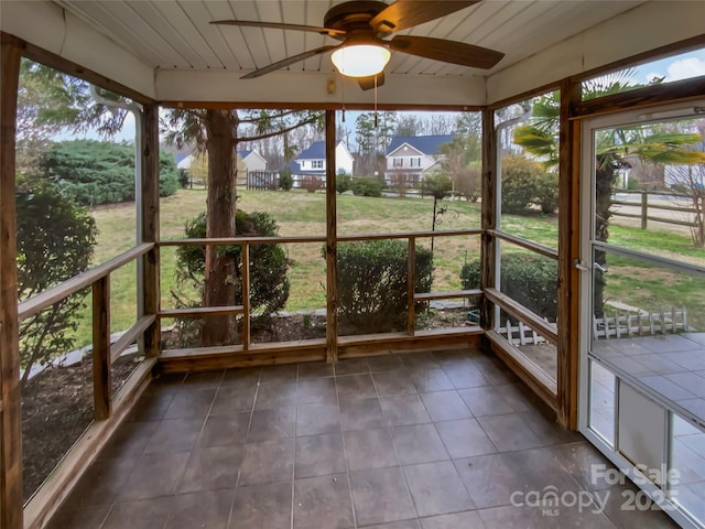 unfurnished sunroom featuring a ceiling fan