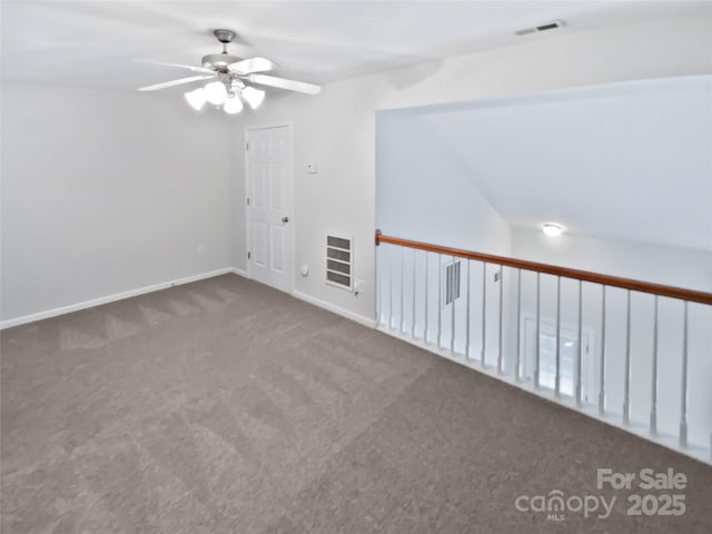 carpeted empty room featuring visible vents, ceiling fan, and baseboards