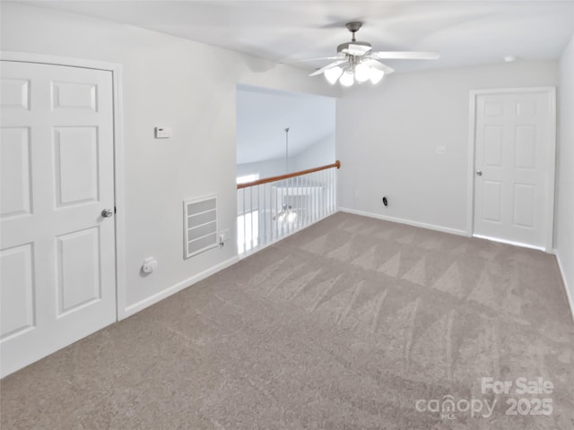 spare room with carpet floors, visible vents, baseboards, and a ceiling fan