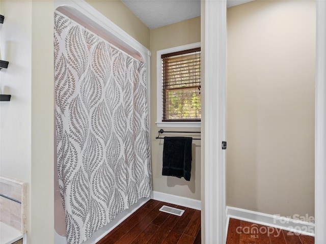 bathroom with visible vents, baseboards, and wood finished floors