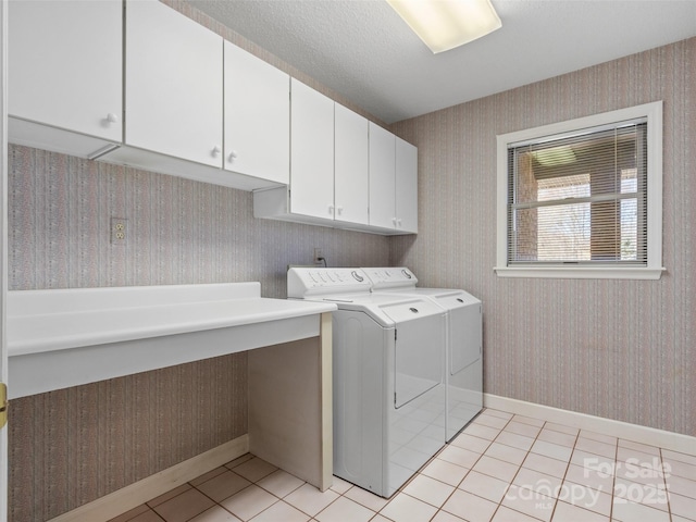 washroom with light tile patterned floors, baseboards, wallpapered walls, separate washer and dryer, and cabinet space
