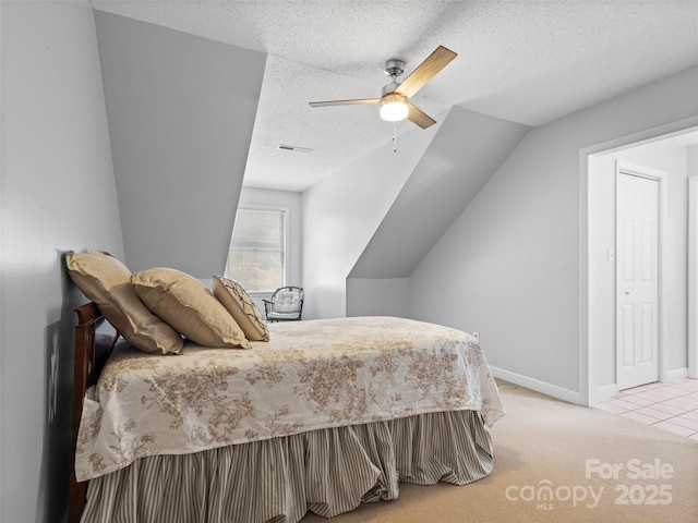 bedroom featuring visible vents, ceiling fan, baseboards, light carpet, and a textured ceiling