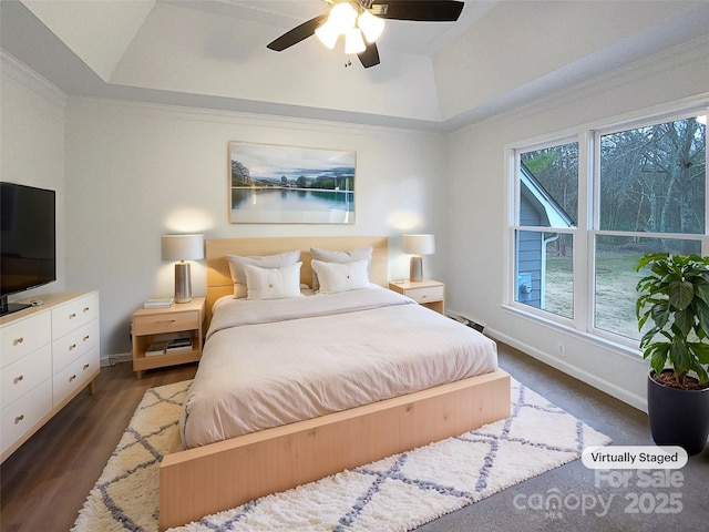 bedroom featuring ornamental molding, wood finished floors, a raised ceiling, and baseboards