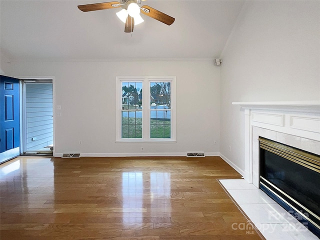 unfurnished living room featuring visible vents, a fireplace, and wood finished floors