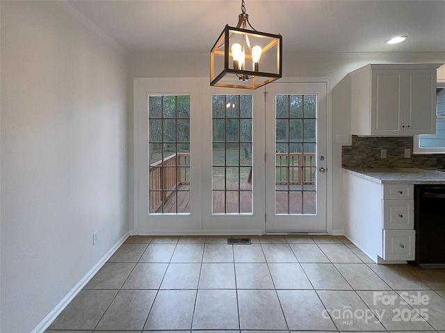 unfurnished dining area featuring visible vents, light tile patterned flooring, a wealth of natural light, and baseboards