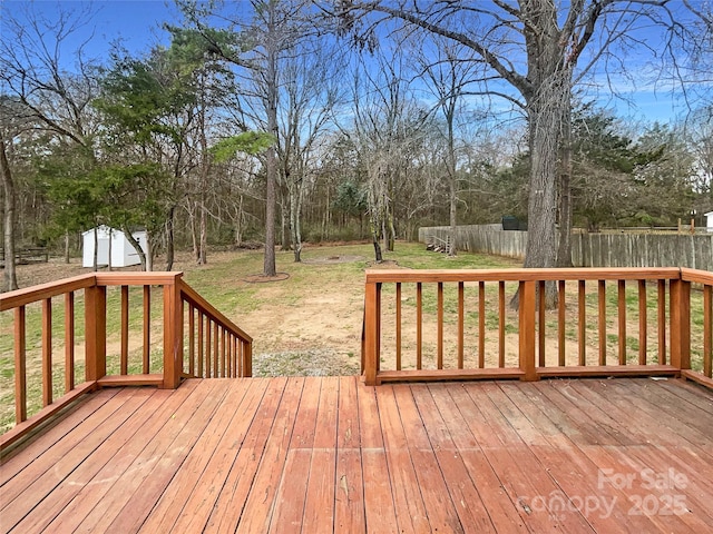 wooden deck with a yard, a shed, an outdoor structure, and fence