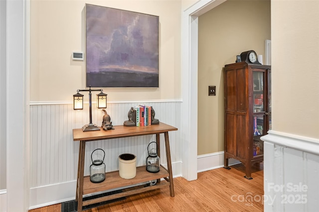 interior space featuring a wainscoted wall and wood finished floors