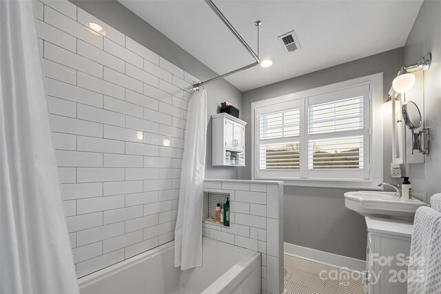 bathroom featuring vanity, shower / bath combination with curtain, visible vents, and baseboards