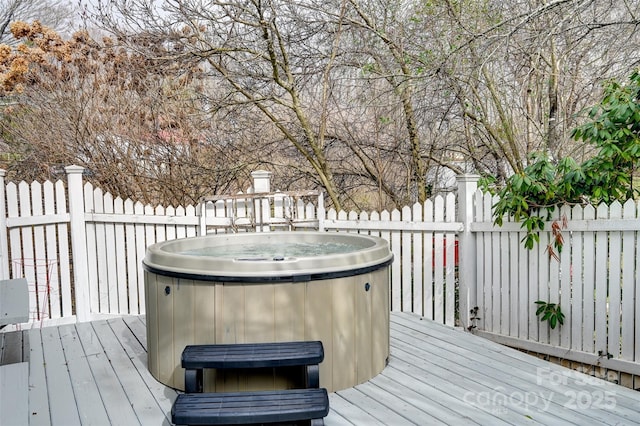 wooden deck featuring fence and a hot tub