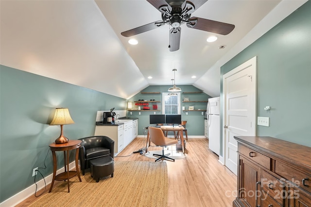 home office featuring light wood-style floors, ceiling fan, baseboards, and vaulted ceiling