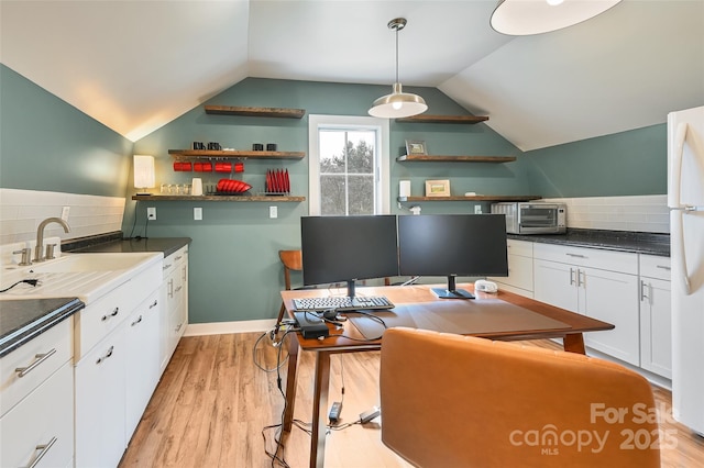 kitchen with white cabinets, a sink, light wood finished floors, and open shelves