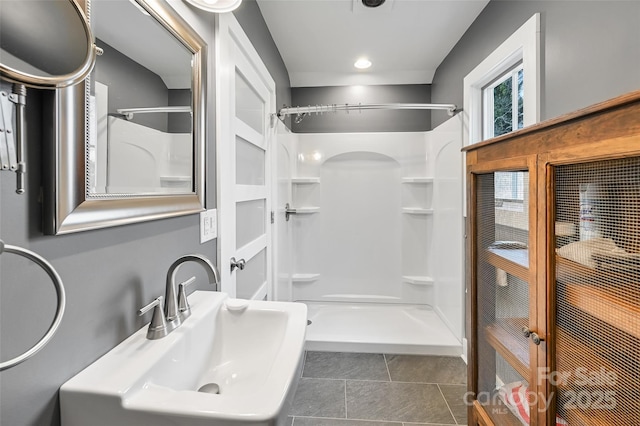 bathroom featuring a sink, a shower stall, and tile patterned floors