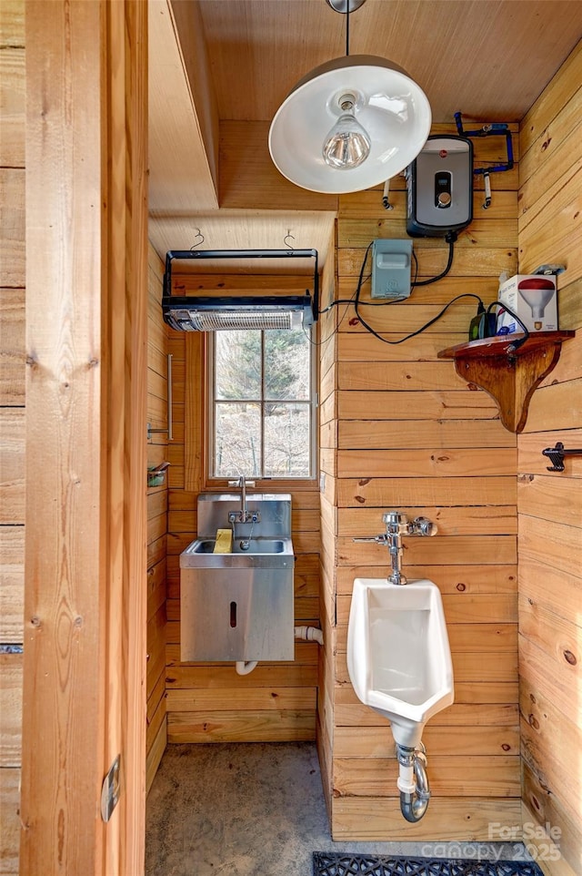 bathroom with wood walls and a sink