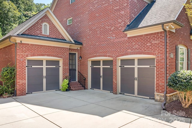 view of front facade featuring concrete driveway, brick siding, a garage, and a shingled roof