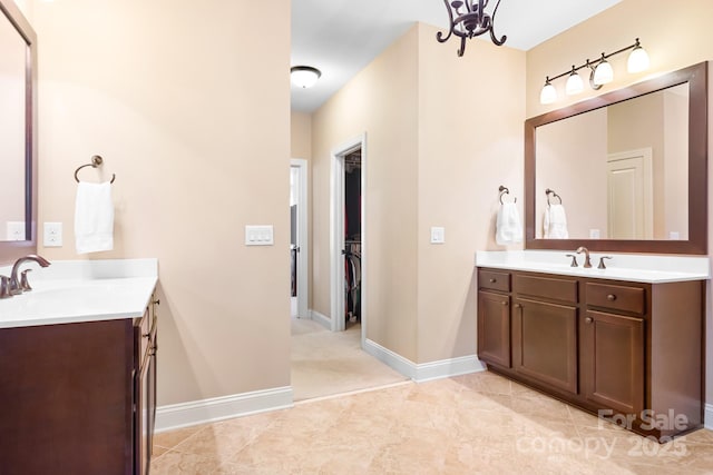 full bathroom featuring two vanities, baseboards, and a sink