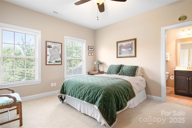 bedroom featuring baseboards, visible vents, ceiling fan, light carpet, and connected bathroom