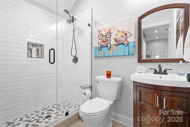 full bath with a shower stall, toilet, vanity, and baseboards