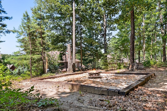 view of yard with an outdoor fire pit and fence