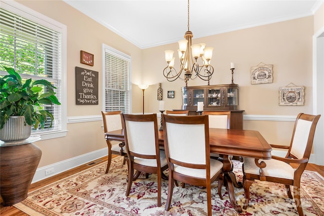 dining room featuring a wealth of natural light, crown molding, and wood finished floors