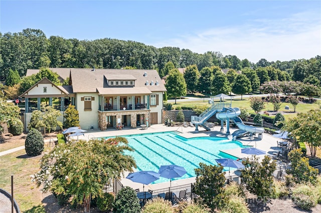 pool featuring a patio, fence, and a water slide