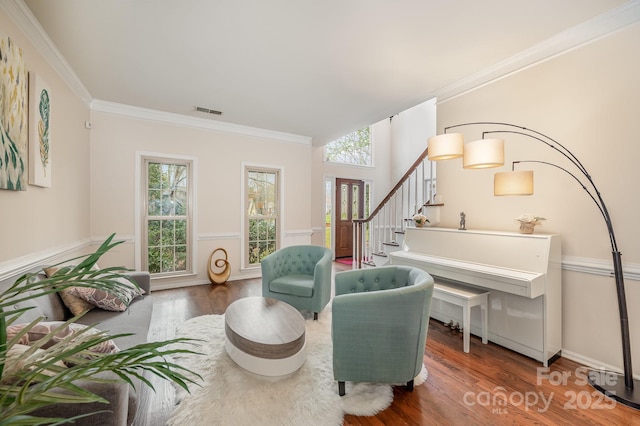 living room with wood finished floors, ornamental molding, stairway, and visible vents