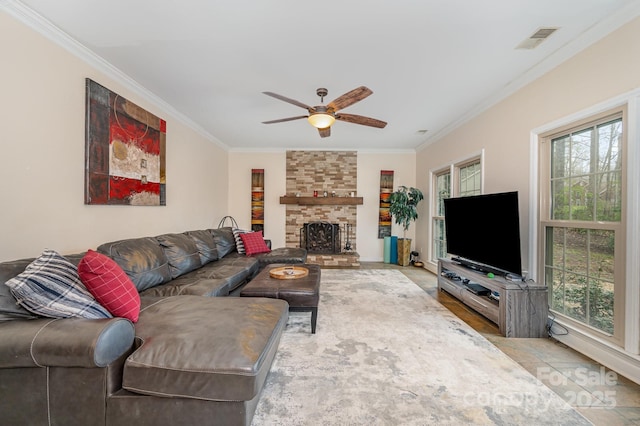 living room with a fireplace, ceiling fan, visible vents, and crown molding