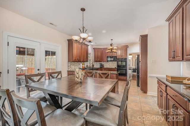 dining space featuring a notable chandelier, visible vents, french doors, and light tile patterned floors