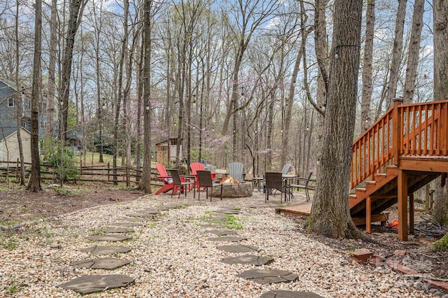 view of yard featuring a fire pit, a wooden deck, fence, and stairway