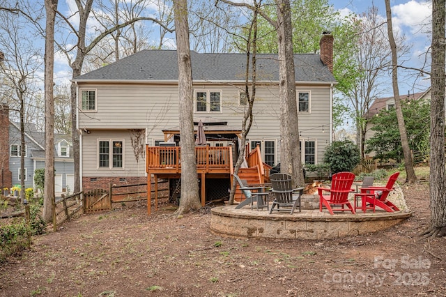 rear view of house with a fire pit, a patio area, a chimney, a wooden deck, and a fenced backyard