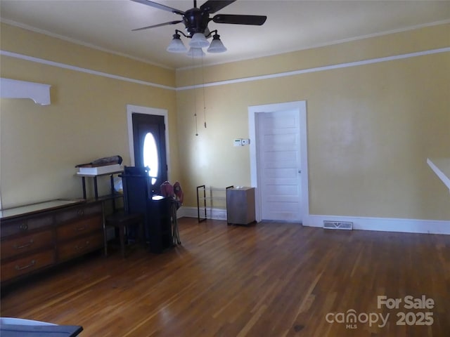 interior space featuring ornamental molding, wood finished floors, visible vents, and baseboards