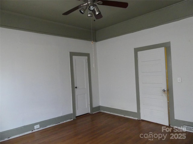 spare room featuring ceiling fan, baseboards, and wood finished floors