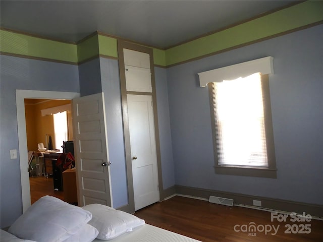 bedroom featuring dark wood-style floors and visible vents