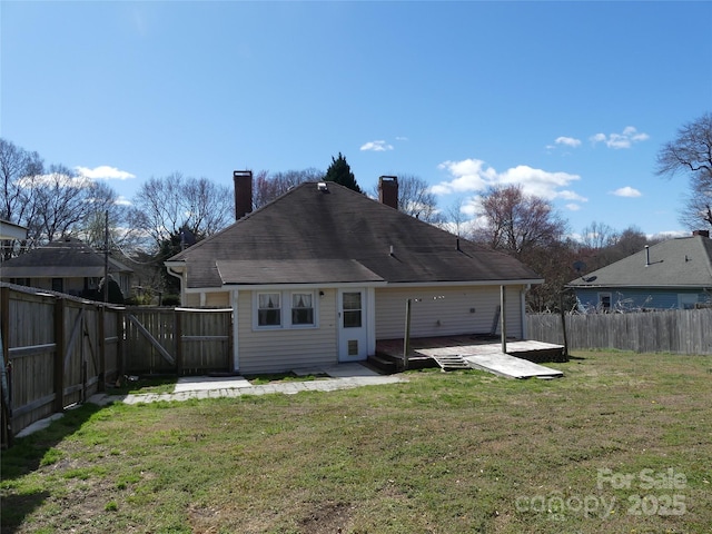 rear view of property with a fenced backyard, a lawn, and a patio