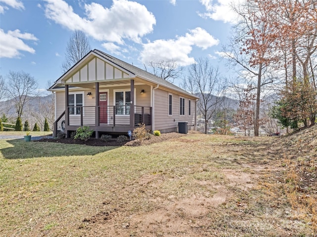 view of front of home featuring central AC, a porch, board and batten siding, and a front yard