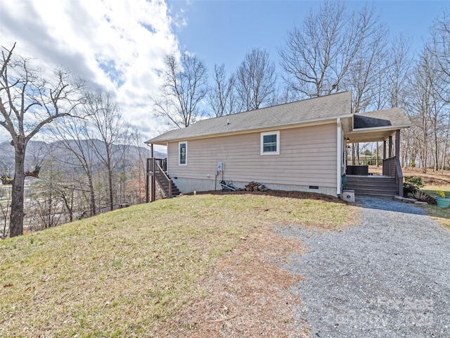 back of property with a porch, a lawn, crawl space, a carport, and driveway