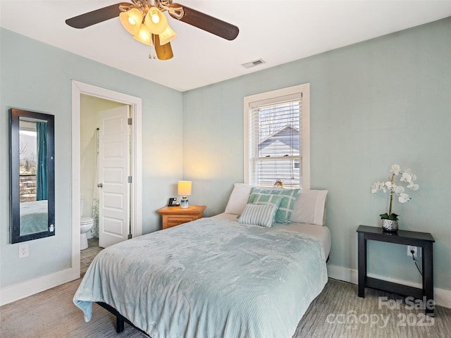 bedroom with ceiling fan, ensuite bath, visible vents, and baseboards