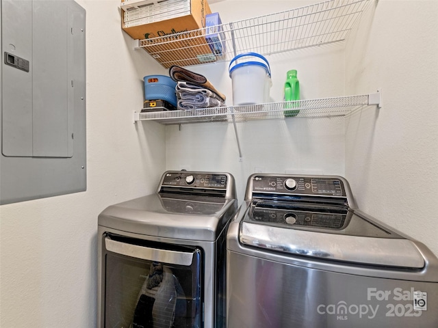 laundry area with laundry area, washing machine and clothes dryer, and electric panel