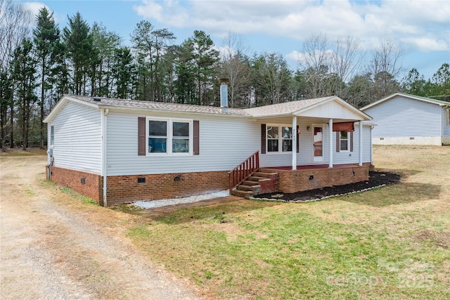 manufactured / mobile home featuring a front yard, covered porch, driveway, and crawl space