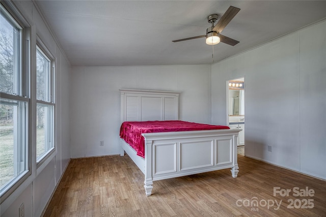 unfurnished bedroom featuring ceiling fan, connected bathroom, and wood finished floors