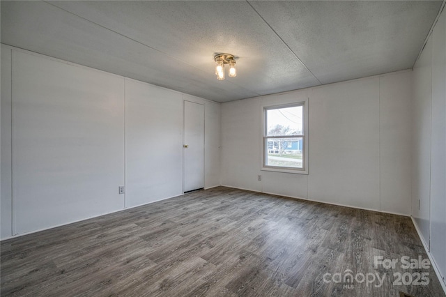 spare room featuring a textured ceiling and wood finished floors