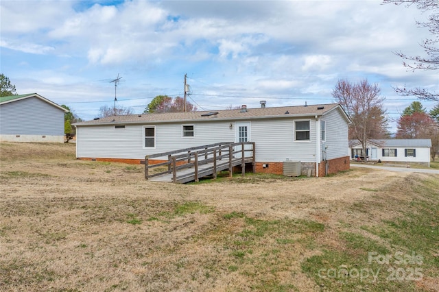 rear view of property featuring central air condition unit, crawl space, and a yard