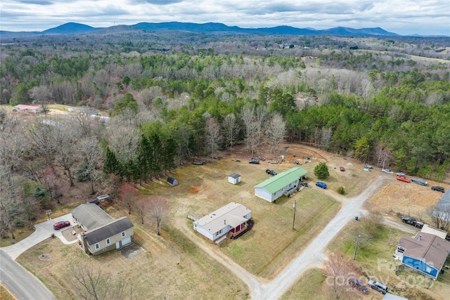 aerial view featuring a wooded view and a mountain view