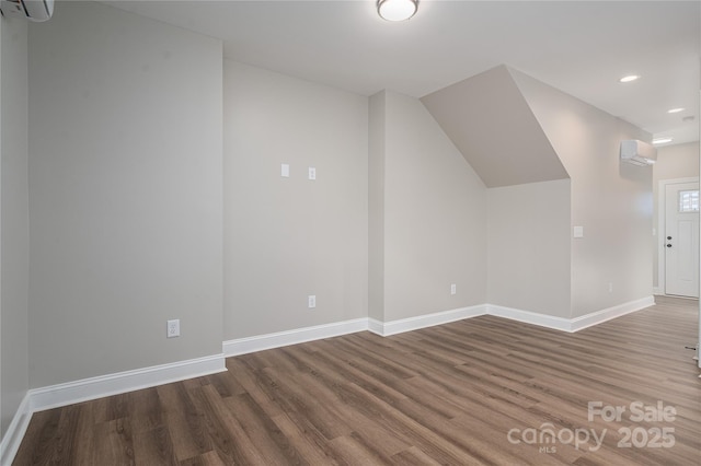 additional living space with recessed lighting, baseboards, wood finished floors, and a wall mounted AC