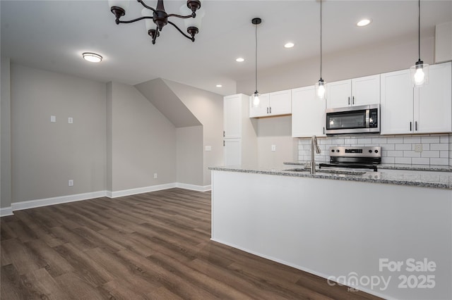 kitchen featuring appliances with stainless steel finishes, decorative backsplash, light stone counters, and dark wood-style floors